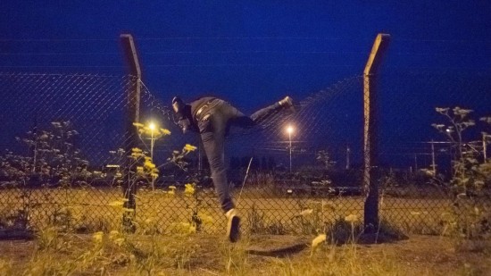 Ein Flchtling klettert auf das Gelnde des Eurotunnels in Calais. (dpa / picture-alliance / Zoltan Balogh)